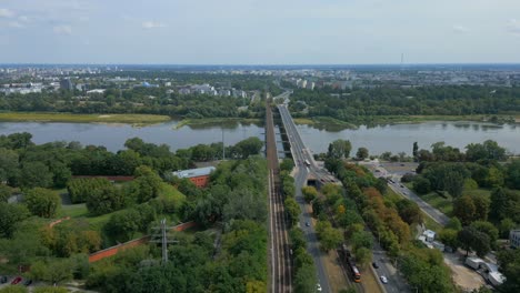 Vista-Aérea-De-Un-Puente-Y-Vías-De-Tranvía-Sobre-El-Río-Vístula-En-Varsovia,-Que-Une-Praga-Polnoc-Y-El-Barrio-De-Zoliborz