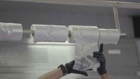 Hispanic-worker-in-supermarket-with-plastic-bags-for-packaging-products