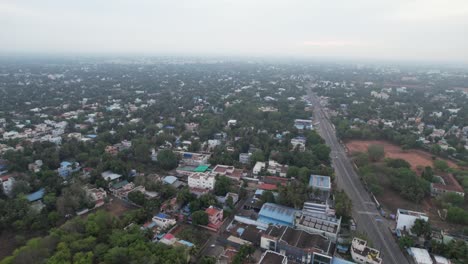 Imágenes-Aéreas-De-Tanjore-Durante-Una-Mañana-Con-Niebla,-Que-Muestran-La-Carretera-Principal,-Los-Edificios-Gubernamentales-Y-Los-Hospitales-En-Las-Afueras-De-La-Ciudad.