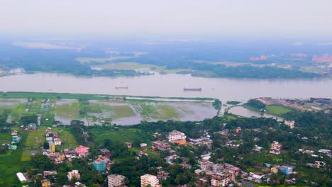 Vista-Aérea-De-Bangladesh,-Ciudad-De-Barisal-Con-El-Río-Kirtankhola-Al-Fondo-Y-Barcos-De-Carga-En-El-Agua