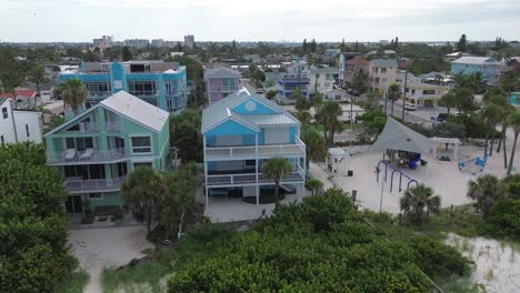 A-blue-coastal-house-sits-on-the-edge-of-paradise,-with-its-hurrican-shutters-on