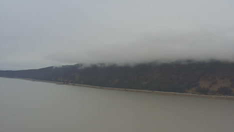 Drone-flying-high-over-lake-George-and-the-highway-near-Canberra,-ACT