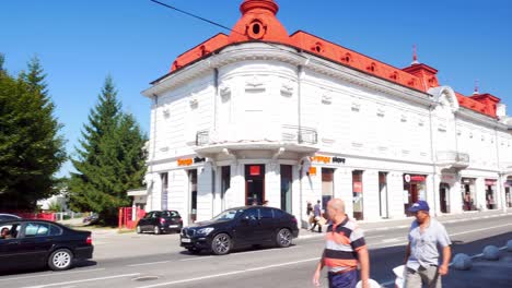 Panning-shot,-left-to-right,-of-the-main-street-in-Curtea-de-Arges-on-a-sunny-and-warm-summer-day