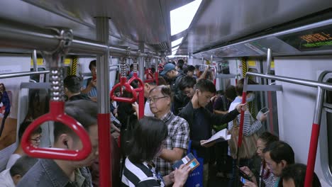 Viajeros-En-Un-Tren-De-Transporte-Público-Lleno-De-Gente-O-En-Un-Tren-Mrt-En-La-Red-De-Transporte-Subterráneo-De-Hong-Kong