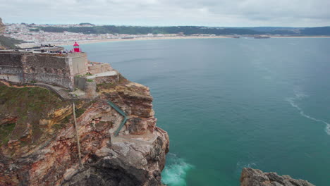 Fantastic-cinematic-aerial-view-over-the-famous-Nazare-lighthouse-in-Portugal-on-a-summer-day