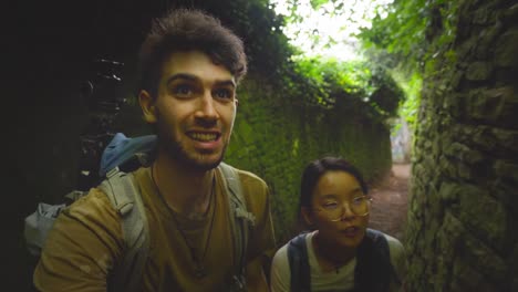 Vibrant-white-man-and-asian-woman-couple-trek-the-scenic-Philosopher's-Trail-in-Heidelberg,-Germany,-capturing-their-joyful-exploration-with-a-camera