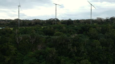 Vista-Aérea-De-Un-Parque-Eólico-Situado-En-La-Cima-De-Una-Montaña-Cerca-De-La-Costa-De-Una-Isla-Tropical-En-La-Región-Del-Océano-Pacífico