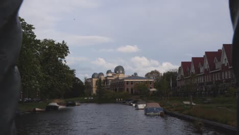 Slider-shot-of-university-observatory-along-canal-in-Leiden,-the-Netherlands