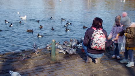 Madre-Y-Niños-Pequeños-Alimentando-A-Los-Patos-En-Un-Lago-En-Saltwell-Park,-Gateshead,-Reino-Unido,-Inglaterra