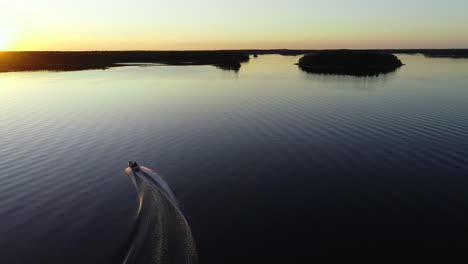 Drone-follow-shot-of-boat-turning-in-beautiful-sunset