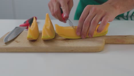 Un-Chef-Cortando-Con-Cuidado-Rodajas-De-Melón,-Preparándolas-Para-Servir-O-Añadirlas-A-Un-Plato.