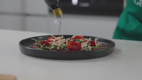 Un-Chef-Rociando-Aderezo-Sobre-Una-Ensalada-Fresca,-Completando-La-Preparación.