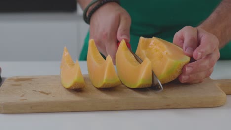 Ein-Koch-Schneidet-Eine-Melone-In-Scheiben,-Schneidet-Sie-Vorsichtig-In-Spalten-Und-Bereitet-Sie-Zum-Servieren-Vor-Oder-Fügt-Sie-Einem-Gericht-Hinzu