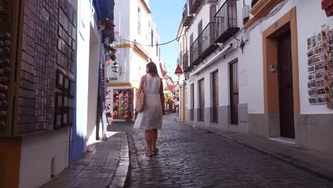 Cordoba,-Andalusia,-Spain---Girl-walking-at-the-narrow-streets-in-the-Jewish-Quarter-shopping-for-souvenirs