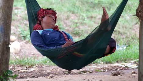 Asian-male-Mahout-sleeps-in-hammock-at-elephant-camp