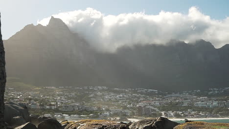 Clouds-rolling-over-a-mountain-next-to-a-beach