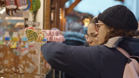 young-hipster-ladies-buys-sweets-from-sweet-shop-stand