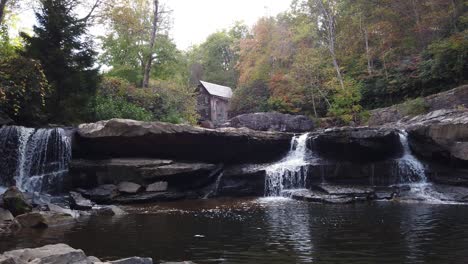 Waterfalls-and-autumn-landscape-in-Babcock-State-Park,-West-Virginia-with-Glade-Creek-Grist-Mill-in-the-background