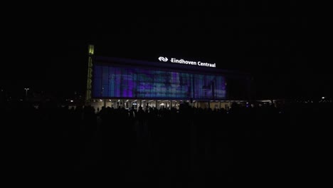 Glow-festival-on-Eindhoven-Centraal-building-exterior,-distance-view