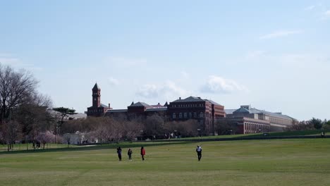 People-walking-across-National-Mall-in-front-of-Smithsonian-Castle-Museum-in-D