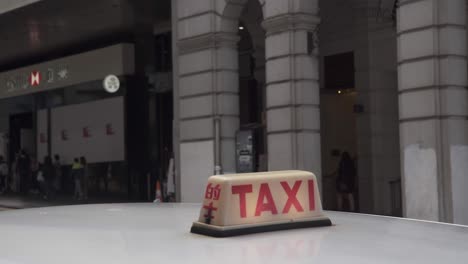 Un-Taxi-Lleva-A-Un-Cliente-Y-Sale-De-La-Estación-De-Taxis-En-El-Distrito-Central-De-Hong-Kong.