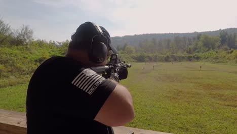 Over-the-Shoulder-Adult-Man-Shoots-Semi-Automatic-Weapon-Empty-Shells-Flying