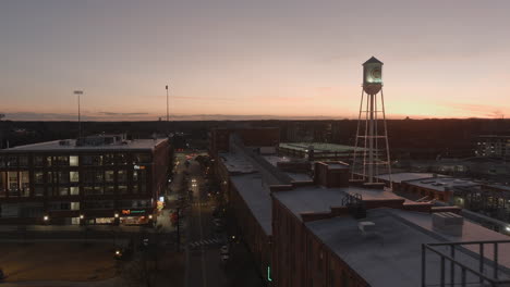 Torre-De-Agua-Del-Campus-Histórico-De-American-Tobacco-En-Durham-Al-Anochecer,-Vista-Aérea