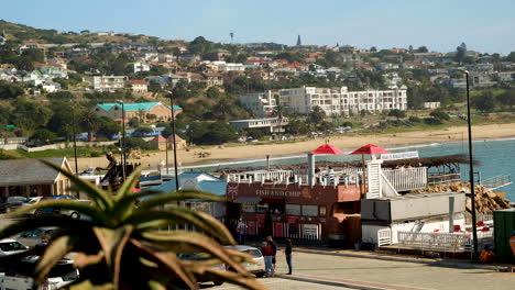 Restaurantes-Frente-Al-Mar-En-Mossel-Bay,-La-Popular-Playa-De-Santos-Al-Fondo