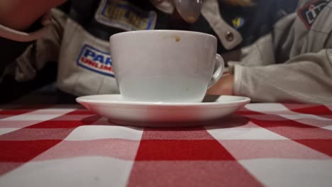 Woman-in-a-motorcycle-jacket-stirring-a-cup-of-coffee-in-an-Italian-restaurant-then-drinking-from-it