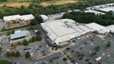 Drone-circling-around-Morrison's-super-market-in-Canterbury,-with-the-car-park-and-other-retail-buildings-in-the-background