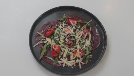 Un-Chef-Prepara-Una-Ensalada-Fresca-Hecha-Con-Jamón,-Tomates,-Verduras-Y-Queso,-Combinando-Ingeniosamente-Los-Ingredientes-Para-Obtener-Un-Plato-Sabroso.