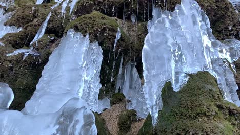 Eisbrocken-Hängen-An-Einer-Steinmauer-Mit-Wassertropfen