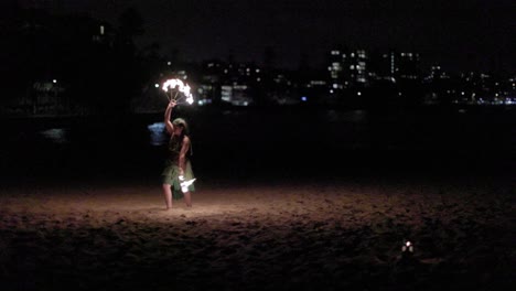 Frau-Führt-Eine-Solo-Feuerwirbelshow-Am-Strand-Vor-Der-Stadt-Auf