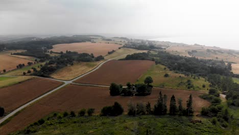 Aerial-view-of-the-beautiful-landscape-with-green-hills-and-trees-in-Odsherred,-Zealand,-Denmark