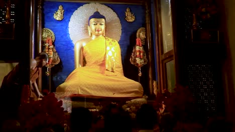 Goldene-Buddha-Statue-Mit-Mönch,-Der-Das-Tägliche-Religiöse-Ritual-Aus-Einem-Flachen-Winkel-Durchführt,-Video-Aufgenommen-Im-Mahabodhi-Tempel-In-Bodhgaya,-Bihar,-Indien-Am-11.-Februar-2020