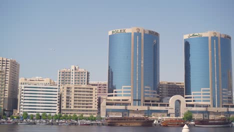 Pan-shot-of-corporate-and-office-buildings-along-dubai-creek-water-way-in-united-arab-emirates