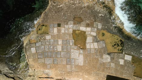 Ascending-bird's-eye-aerial-views-of-the-salt-pans-of-Xwejni-on-Gozo,-Malta-progressively-zooming-out-to-show-both-detail-and-view-from-up-high