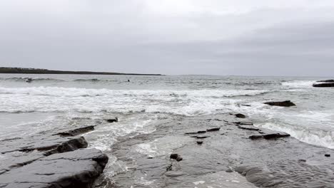 Olas-En-La-Playa-De-Spanish-Point-En-Irlanda---Las-Olas-Golpean-Las-Rocas-En-La-Playa---Surfistas-Esperando-Las-Olas