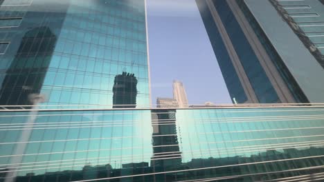 Moving-shot-of-Burj-Khalifa-surrounded-by-skyscrapers-from-metro-window-in-downtown-area-of-Dubai-United-arab-emirates