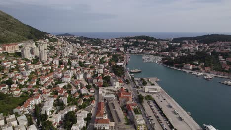 City-and-harbor-Dubrovnik,-Croatia,-aerial-orbit-cloudy-day,-famous-balkan-town