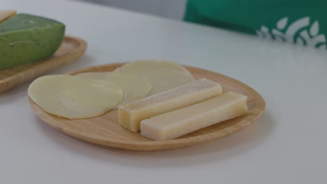 Un-Chef-Coloca-Rebanadas-De-Queso-En-Un-Plato,-Preparándolo-Para-Un-Plato.