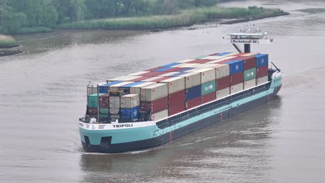 Toma-Panorámica-Del-Portacontenedores-De-Trípoli-Navegando-En-Aguas-Tranquilas-Desde-La-Parte-Aérea-De-Barendrecht,-Países-Bajos,-Buque