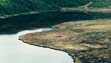 Ein-Rotes-Campingzelt-Wurde-Am-Ufer-Des-Unberührten-Inneren-Sees-Kjøåkertjønna-In-Osen,-Trøndelag,-Norwegen-Aufgestellt-–-Drohne-Fliegt-Vorwärts