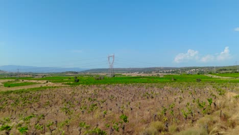 Vista-Aérea-Sobre-Una-Torre-De-Transmisión-Con-Cables-Eléctricos-Rodeada-De-Campos-Agrícolas-En-Francia