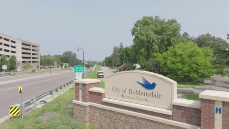 Aerial-view-showing-logo-of-Robbinsdale-city-during-daytime-beside-a-busy-road-in-Minnesota,-USA