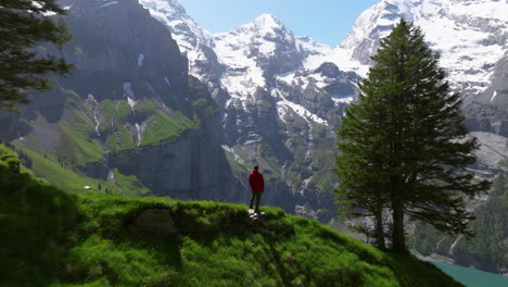 Aerial-Revealed-Hiker-Over-The-Summit-Of-Oeschinensee-Lake-In-The-Bernese-Oberland,-Switzerland