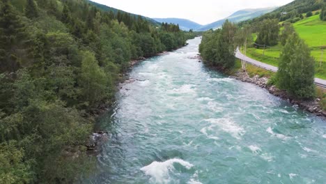 Aerial-view-of-a-flowing-river-surrounded-by-lush-forest-and-scenic-landscape