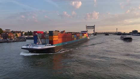 Container-vessel-navigating-river-waterways-during-golden-hour