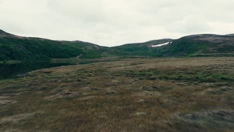 A-Red-Camping-Tent-was-Placed-on-the-Shore-of-Inner-Kjøåkertjønna-Lake-in-Osen,-Trøndelag-County,-Norway---Drone-Flying-Forward