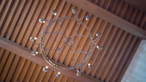 Chandelier-with-ship-wheel-design-on-wooden-ceiling-viewed-from-below